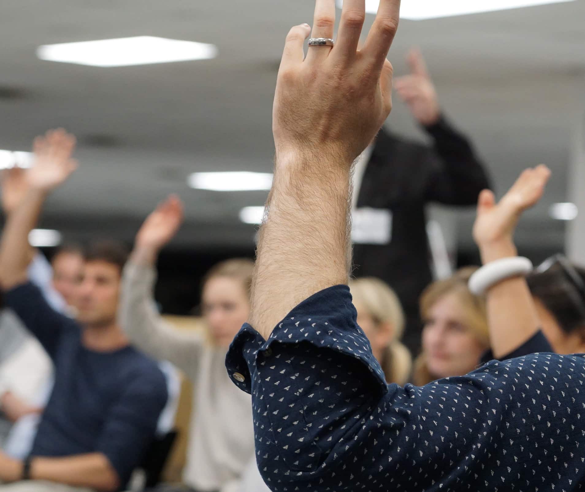 Members of the IDEA jury raise their hands to vote on a design